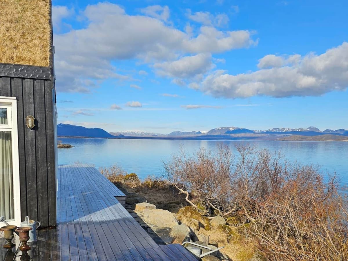 The patio stretches into the lake, with a view of the surrounding landscape